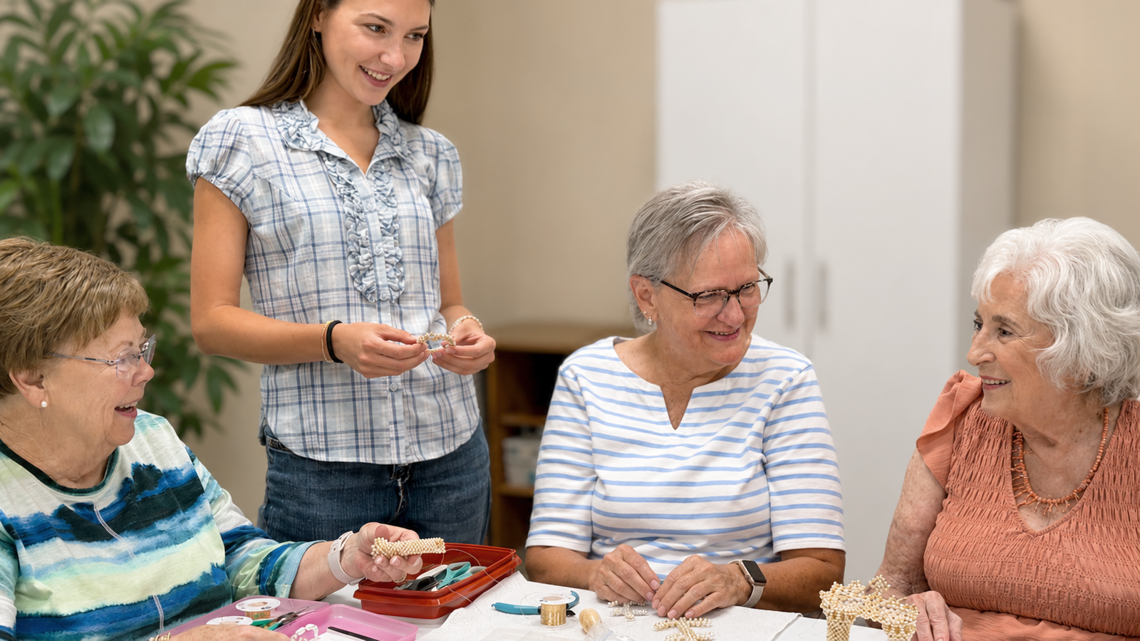 Seniors participating in a beading and jewelry making activity with an instructor at an assisted living community.